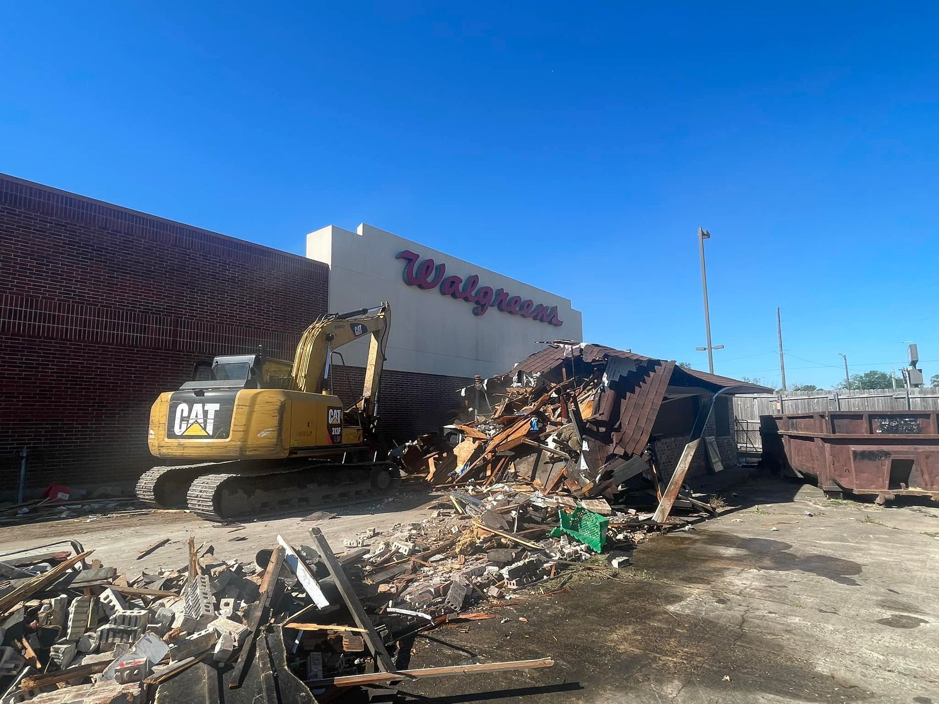 A yellow excavator is sitting on top of a pile of dirt.