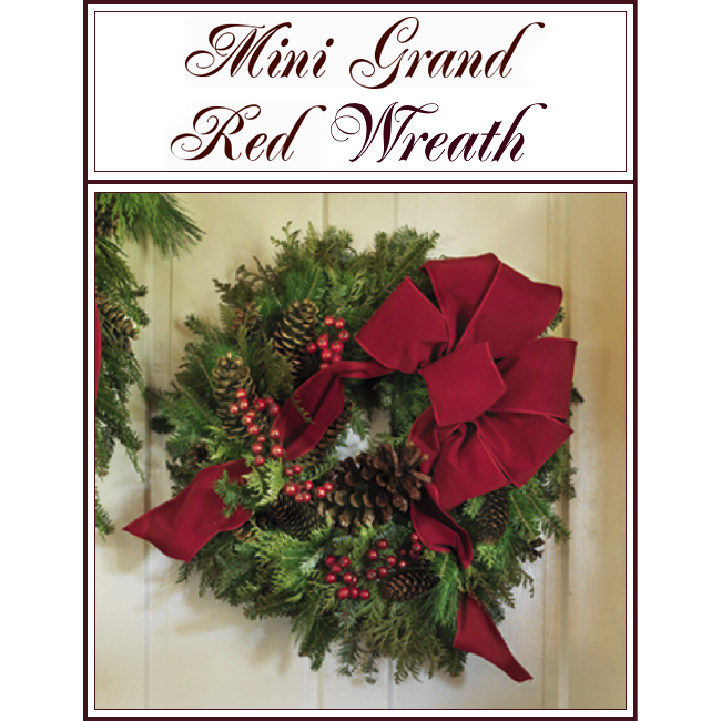 Mini Grand Red Wreath with red bow, berries, pinecones, and greenery on a wall