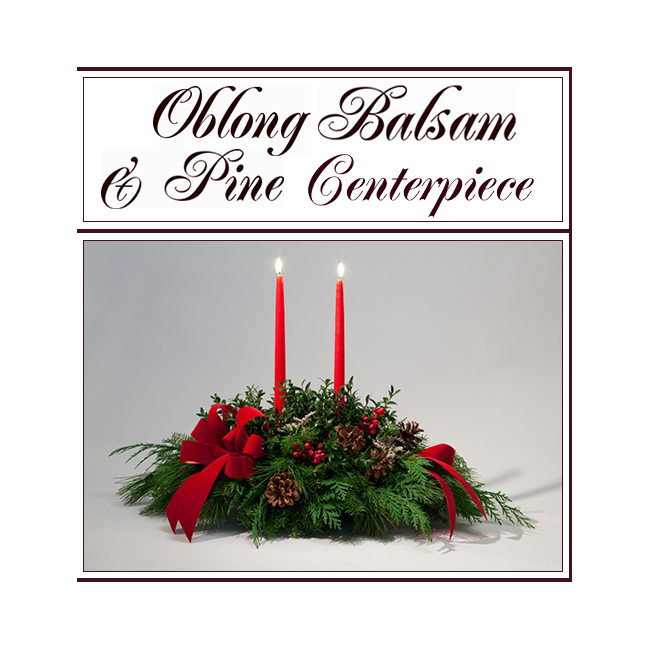 Oblong balsam and pine centerpiece with red candles and poinsettias on a white background