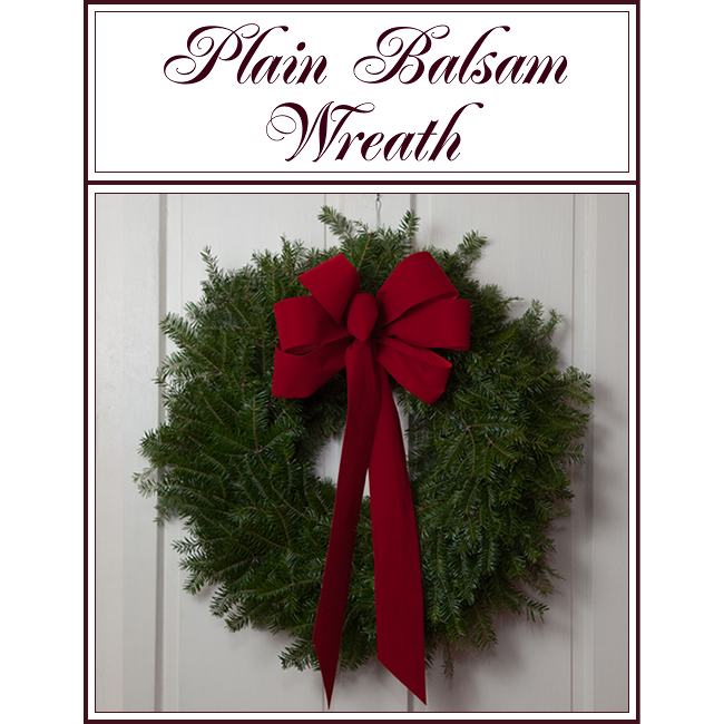 Plain balsam wreath with a red bow hanging on a wall