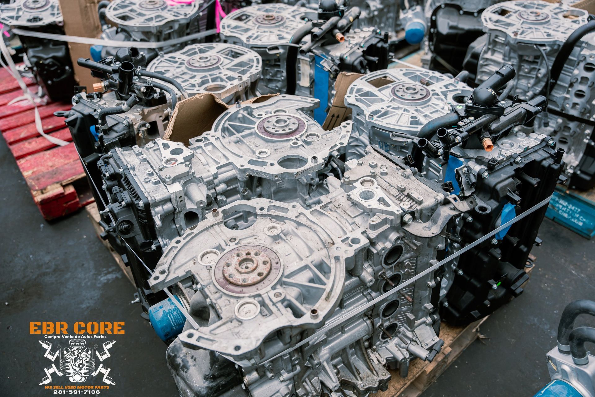 A group of large, grey, automotive engines on a pallet.