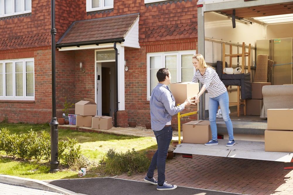 A Man And A Woman Are Loading Boxes Into A Moving Truck  — Greater Newcastle Removals In Rathmines, NSW