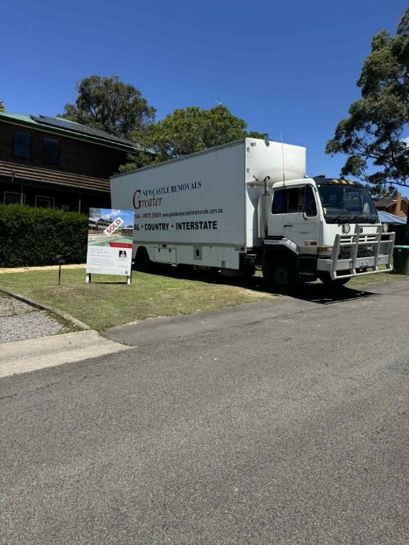 A Mover Truck Outside A Sold House