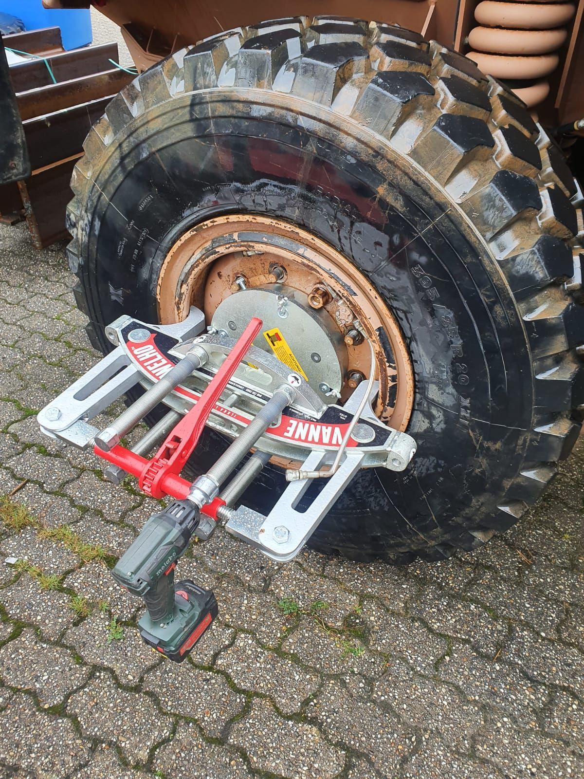 Rengas, johon on kiinnitetty työkalu, istuu tiilisellä jalkakäytävällä.