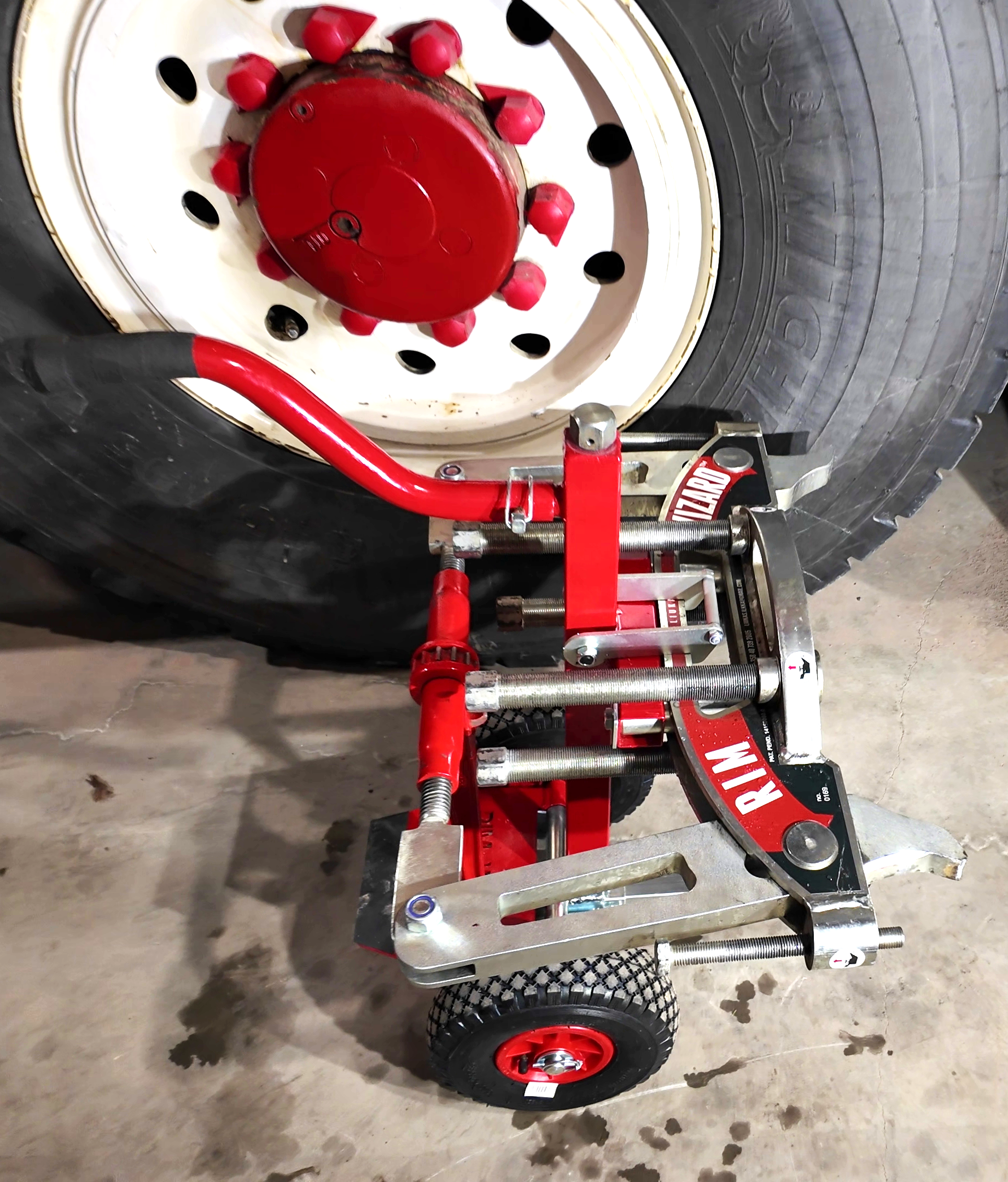 Lähikuva mobiilinosturin renkaasta, jonka edessä Rim Wizard Lifter -nostovaunu.