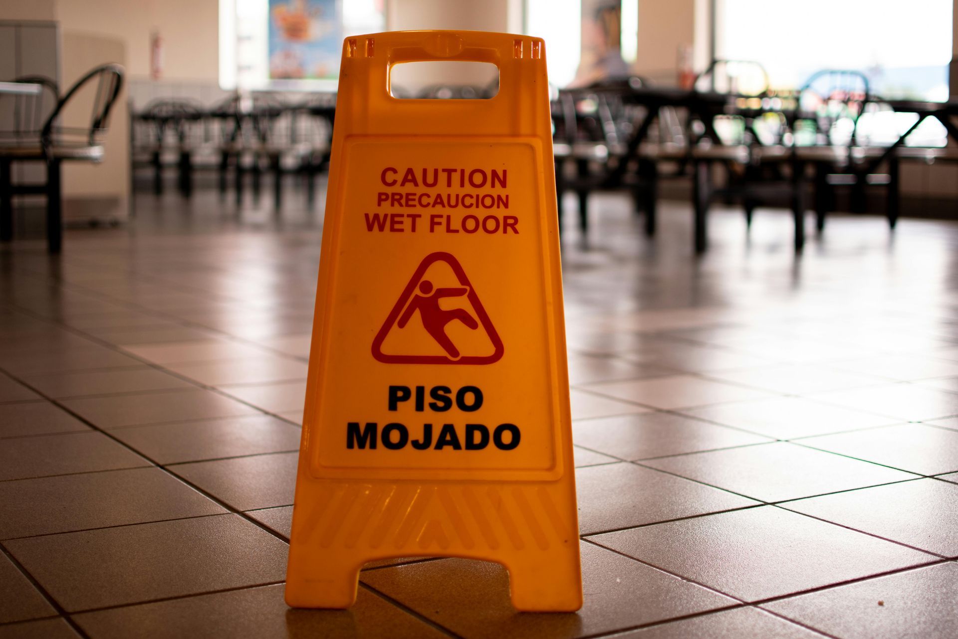 A yellow sign that says caution precaution wet floor piso mojado