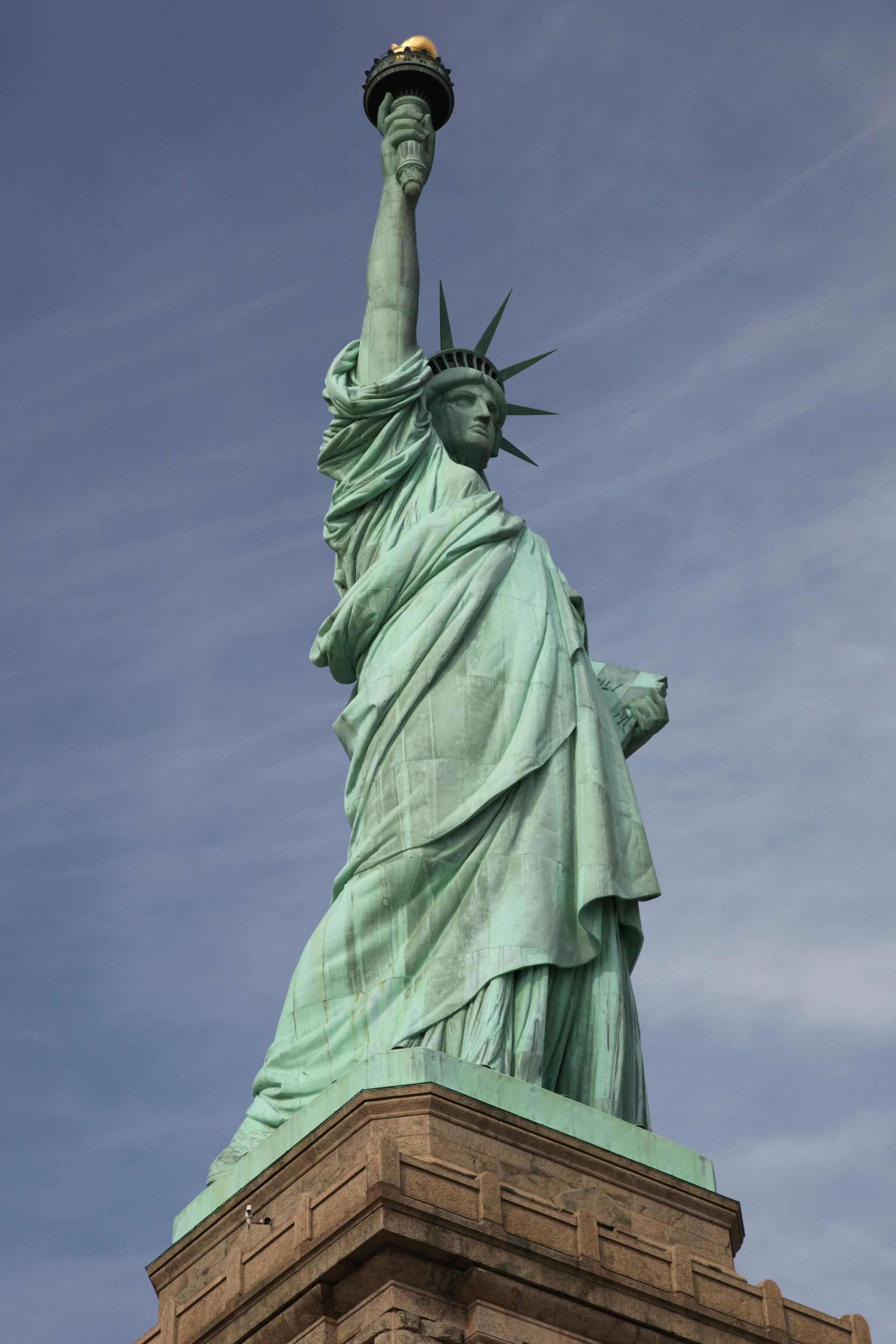 The statue of liberty is standing on top of a building holding a torch.