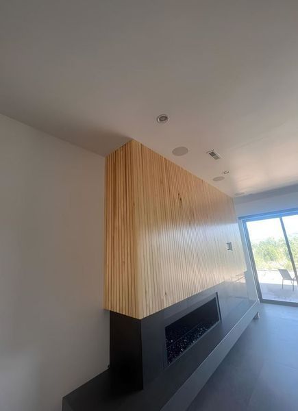 Modern fireplace with a wooden facade, black base, and glass flames.