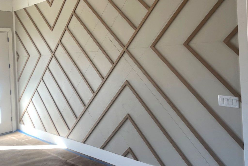 Geometric patterned wall with wooden trim and off-white panels.