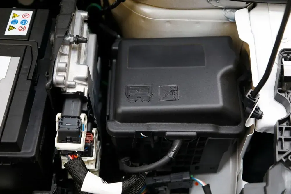 Car Engine Compartment Showing a Black Fuse Box, Battery, and Wiring — Advanced Auto Electrics & Mechanical in Innisfail, QLD