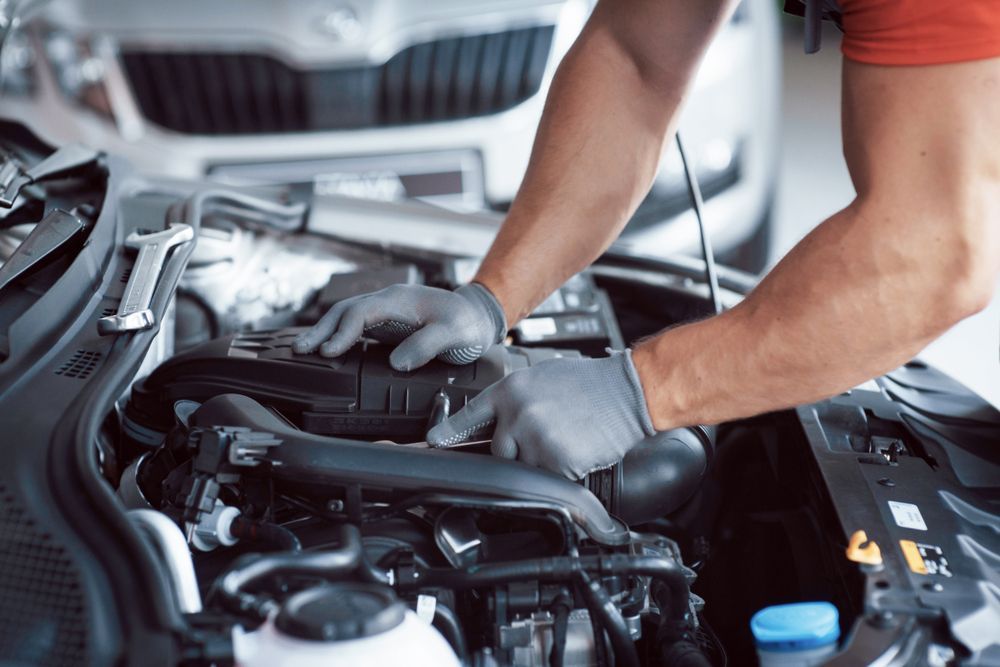 Mechanic Working on a Car Engine, Wearing Gray Gloves — Advanced Auto Electrics & Mechanical in Mission Beach, QLD