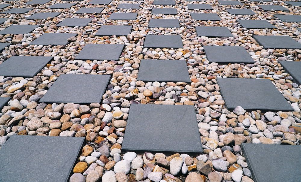 A Row Of Square Tiles Sitting On Top Of A Pile Of Rocks — Envy Landscape Supplies In Urangan, QLD