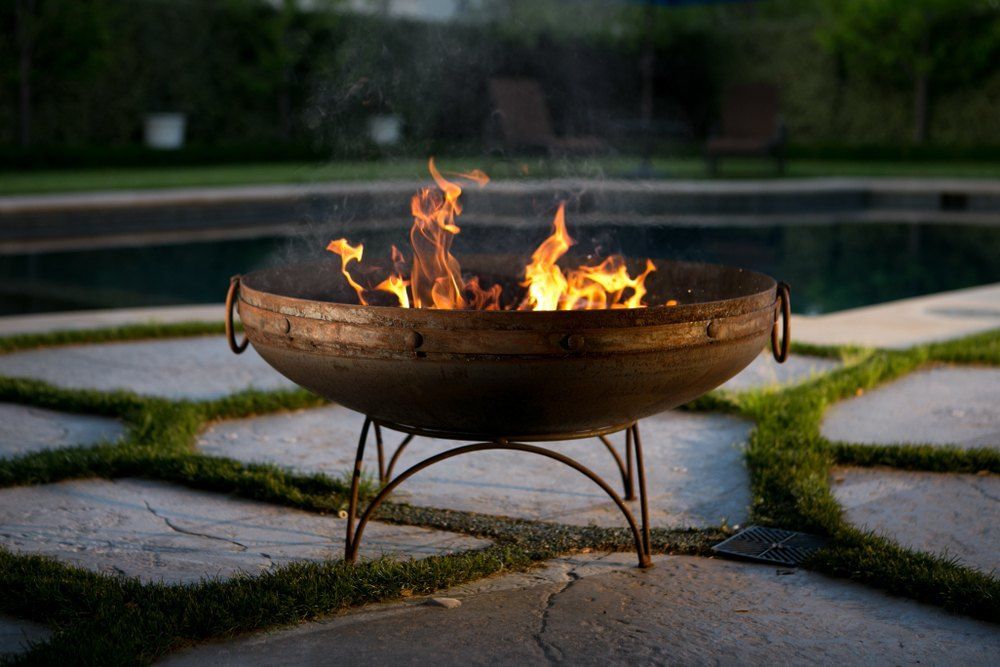 A Fire Pit is Sitting Next to a Swimming Pool — Envy Landscape Supplies In Urangan, QLD