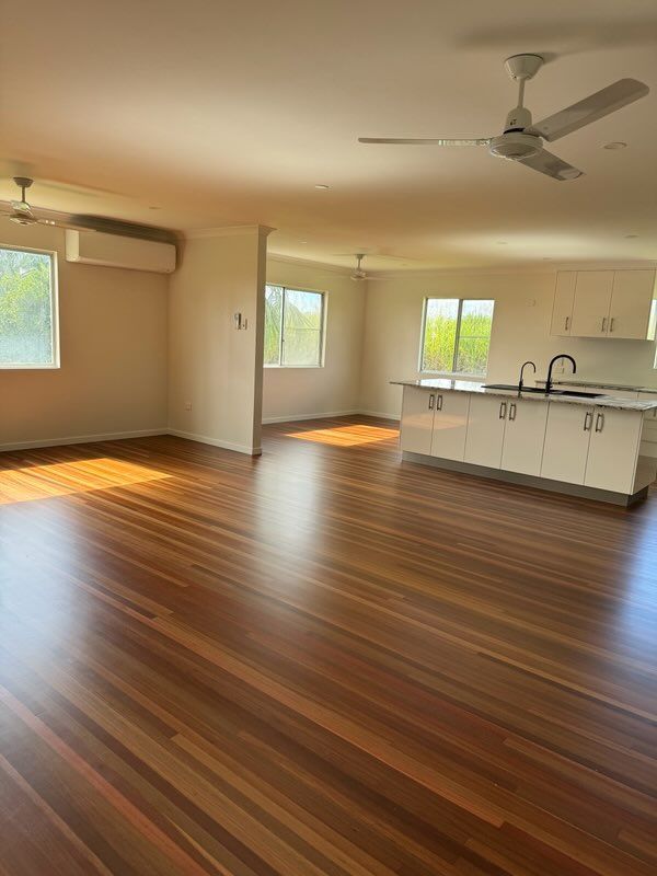 Spacious Interior With Hardwood Floors, White Kitchen Island and Windows — Red Emperor Constructions in Cannonvale, QLD