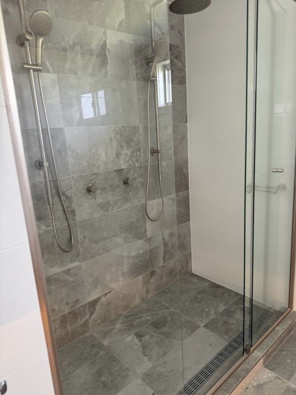 Shower Stall With Gray Marble Tile and Glass Door — Red Emperor Constructions in Cannonvale, QLD