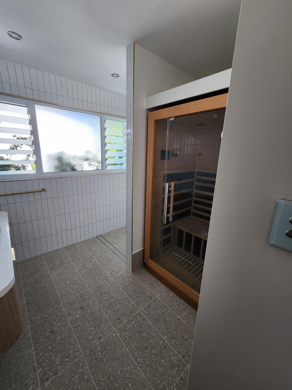 Bathroom With a Sauna, Tiled Walls, and a Window — Red Emperor Constructions in Cannonvale, QLD