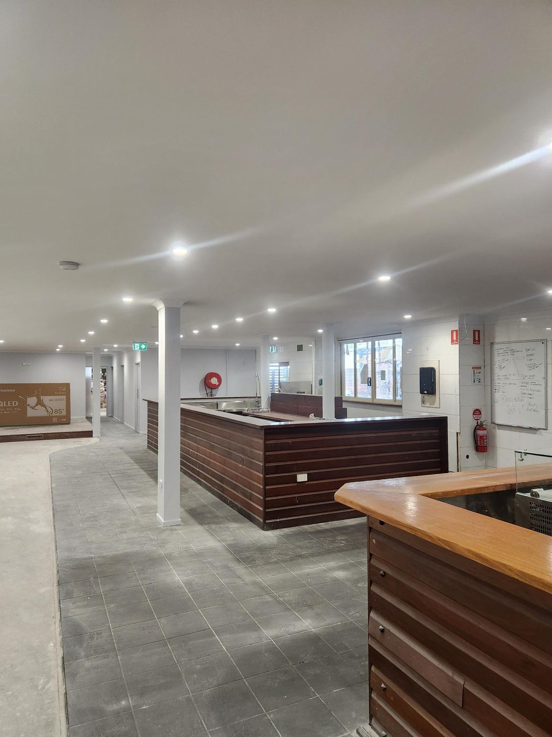 a Newly Renovated Bar Space With a Central Bar and a Concrete Floor — Red Emperor Constructions in Cannonvale, QLD