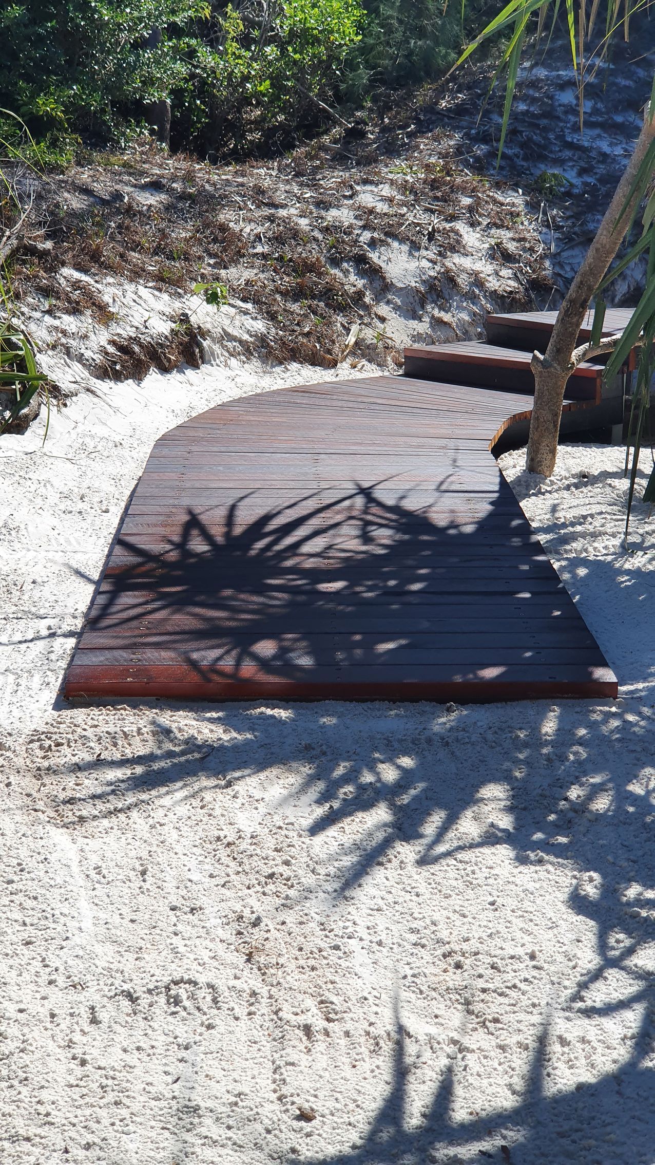 Wooden Walkway on White Sand, Shaded by Plants — Red Emperor Constructions in Cannonvale, QLD