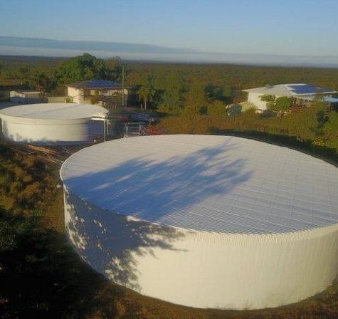 A group of large white tanks sitting on top of a hill — Red Emperor Constructions in Cannonvale, QLD