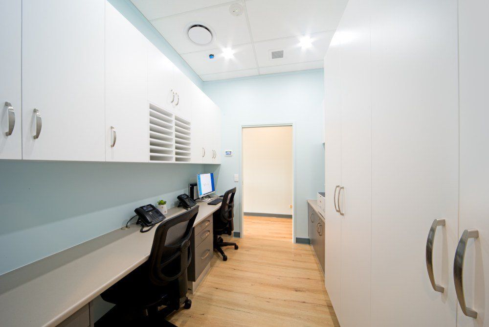 A long hallway with two desks and two chairs in a room — Red Emperor Constructions in Cannonvale, QLD