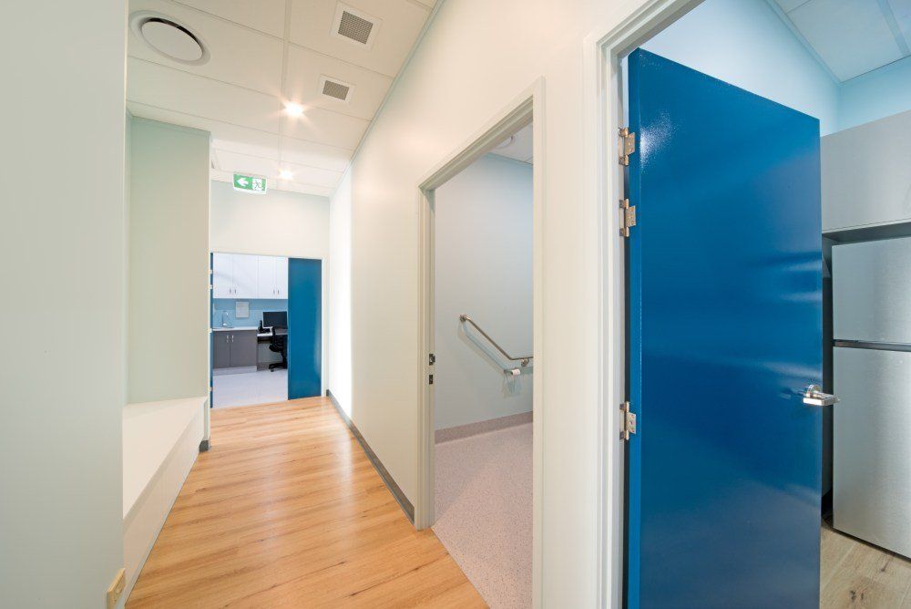 A hallway with a blue door and a white wall — Red Emperor Constructions in Cannonvale, QLD