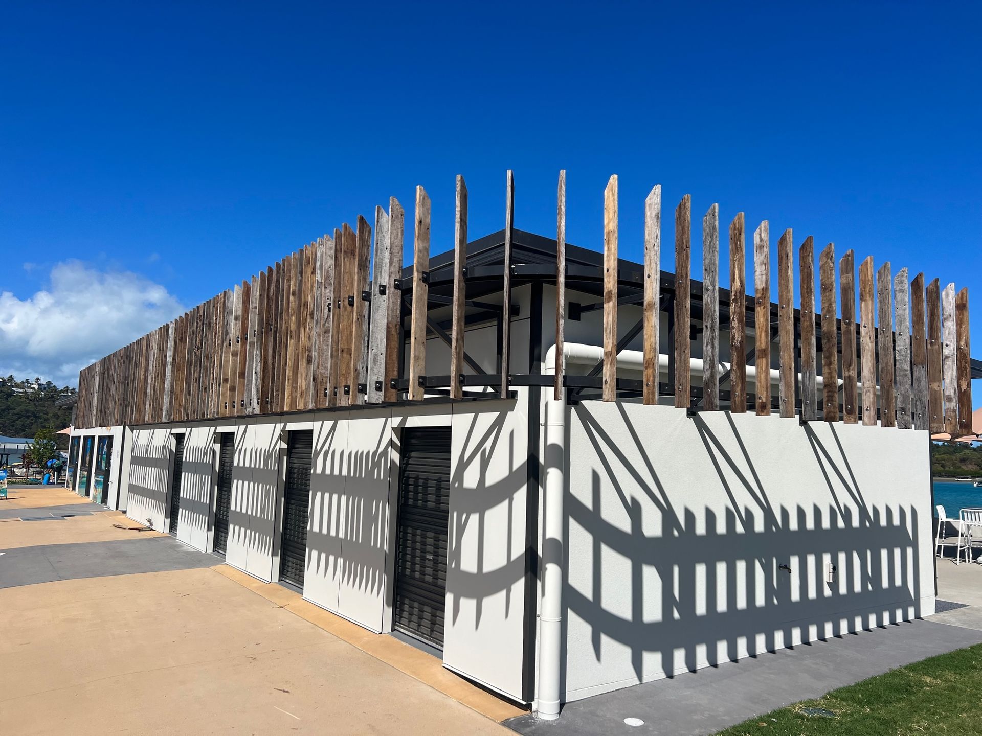 A white building with a wooden fence around it — Red Emperor Constructions in Cannonvale, QLD