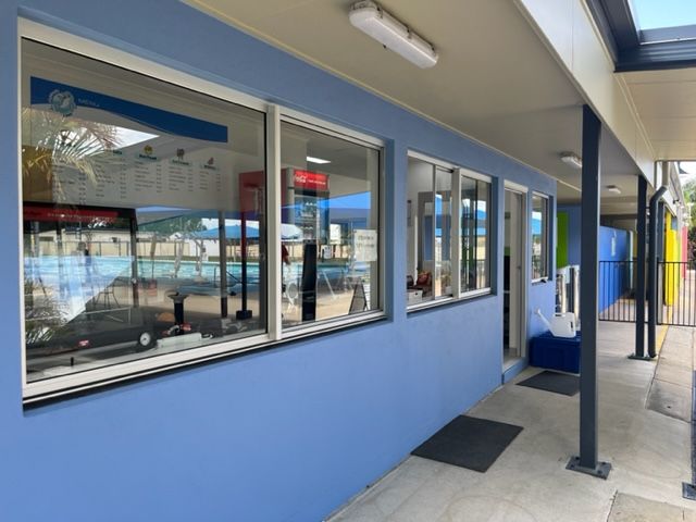 A blue building with a lot of windows and a sign that says water — Red Emperor Constructions in Cannonvale, QLD