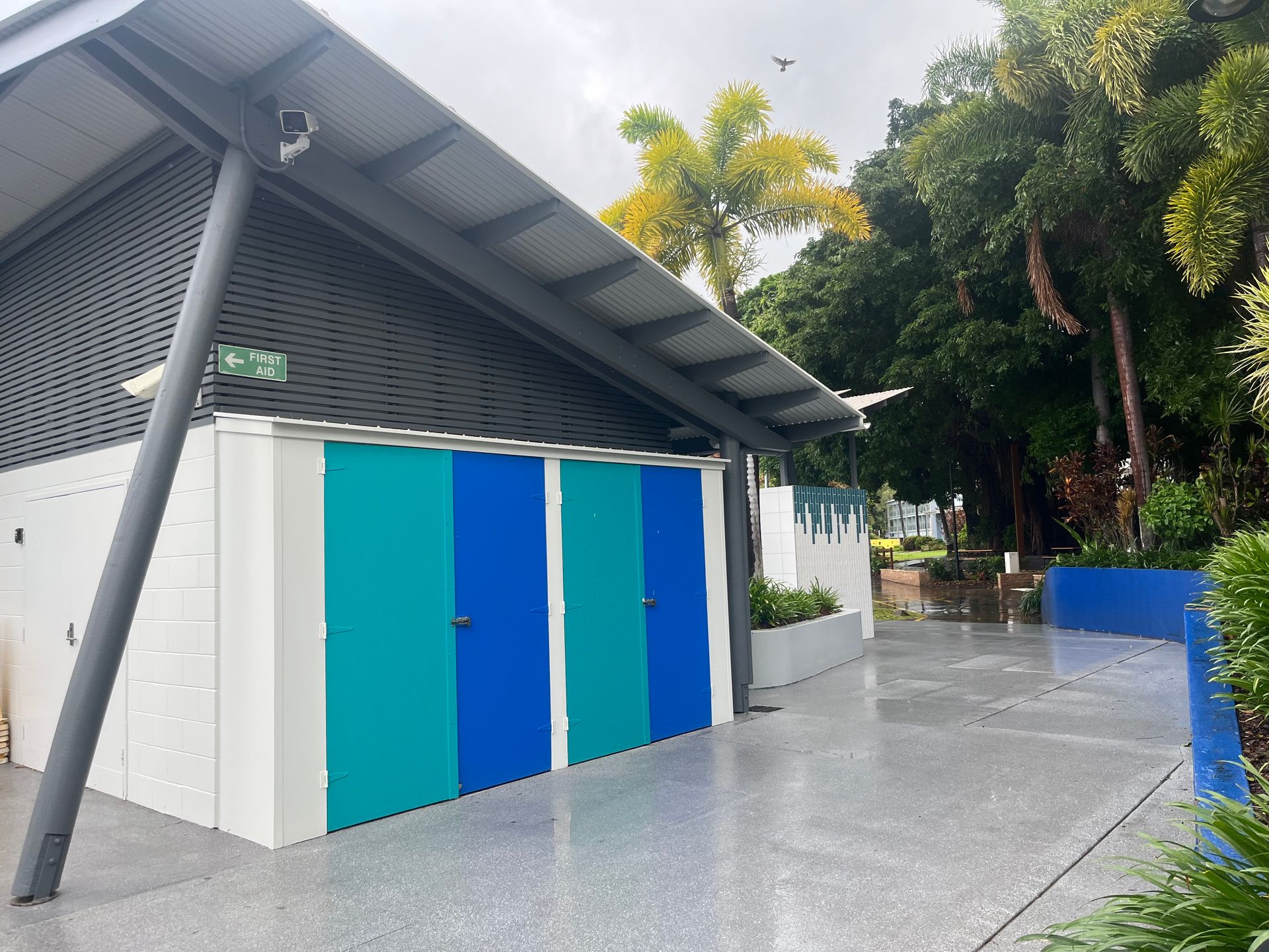 Public Restroom With Blue and Teal Doors, Sloped Roof, and  Gray Concrete Path — Red Emperor Constructions in Cannonvale, QLD