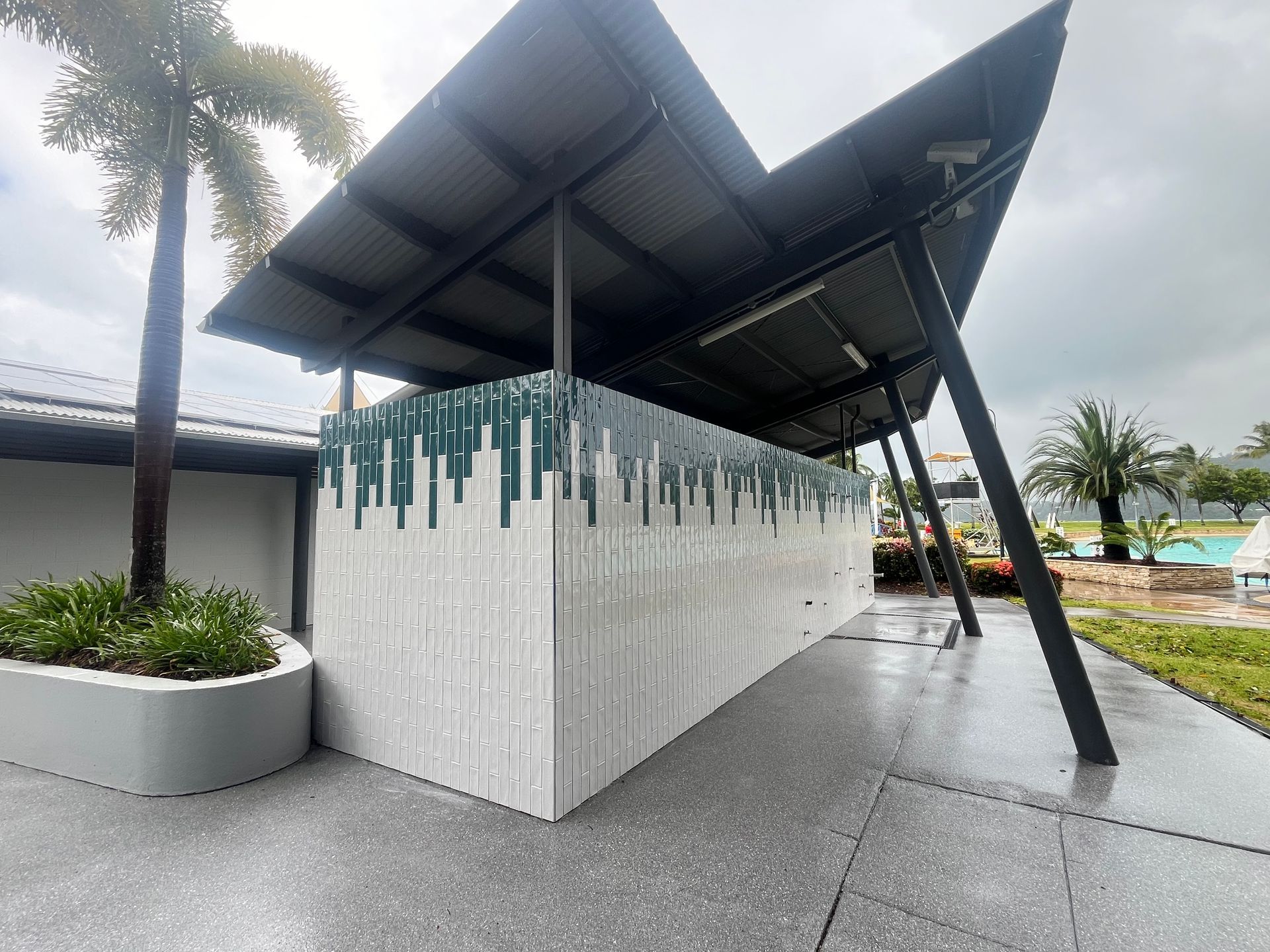 A building with a roof and a fence in front of a pool — Red Emperor Constructions in Cannonvale, QLD