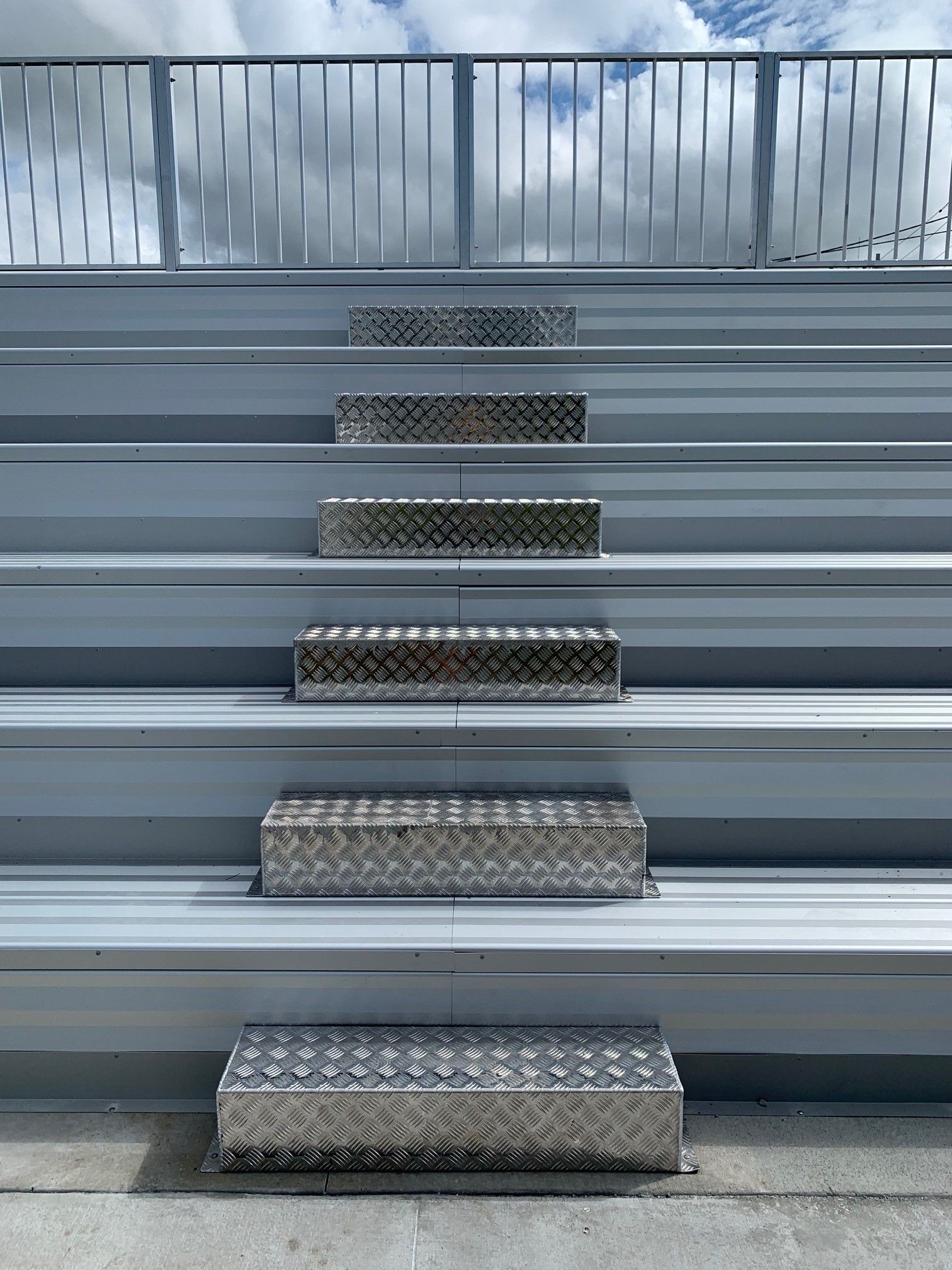 A row of bleachers with a metal railing and stairs leading up to them — Red Emperor Constructions in Cannonvale, QLD