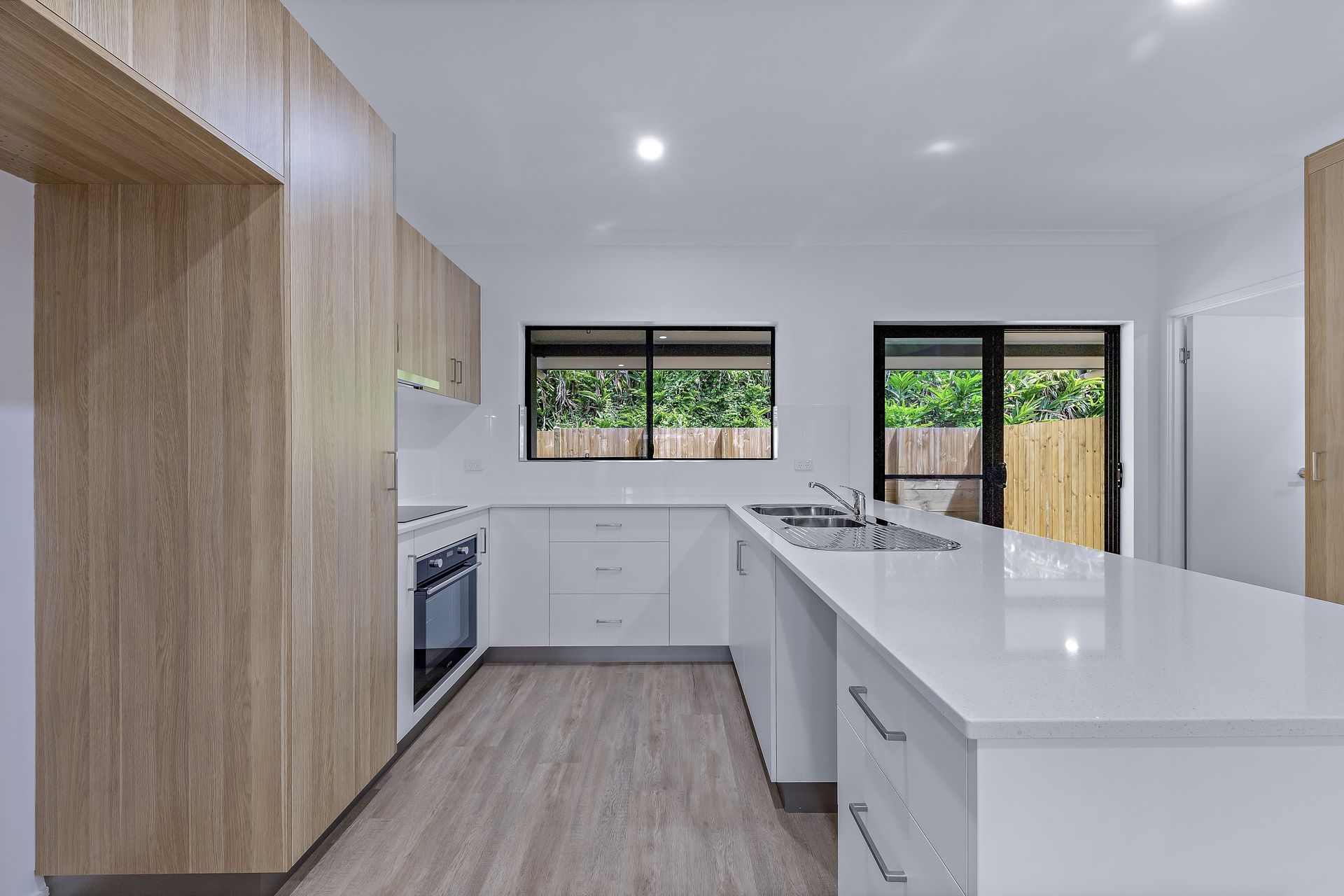 Modern Kitchen With White and Wood Cabinets, Light Countertops — Red Emperor Constructions in Cannonvale, QLD