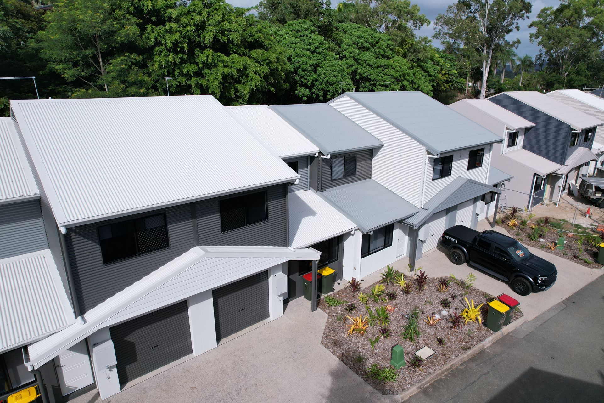 Row of Modern Townhouses With Gray and White Exteriors, Metal Roofs — Red Emperor Constructions in Cannonvale, QLD