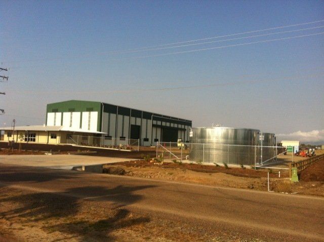 A large building with a lot of tanks in front of it — Red Emperor Constructions in Cannonvale, QLD