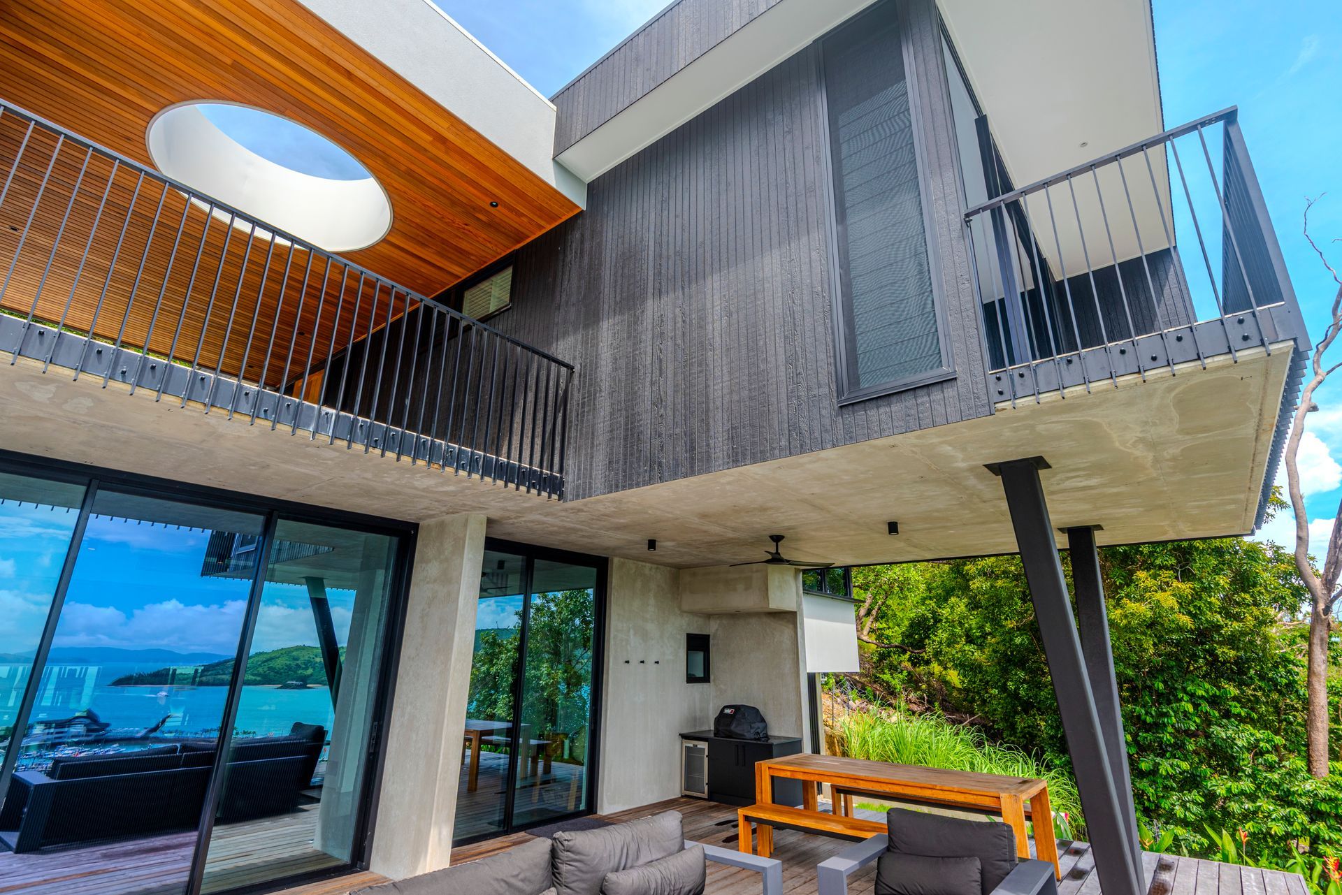 Modern Multi-story House With Balconies Overlooking a Body of Water — Red Emperor Constructions in Cannonvale, QLD