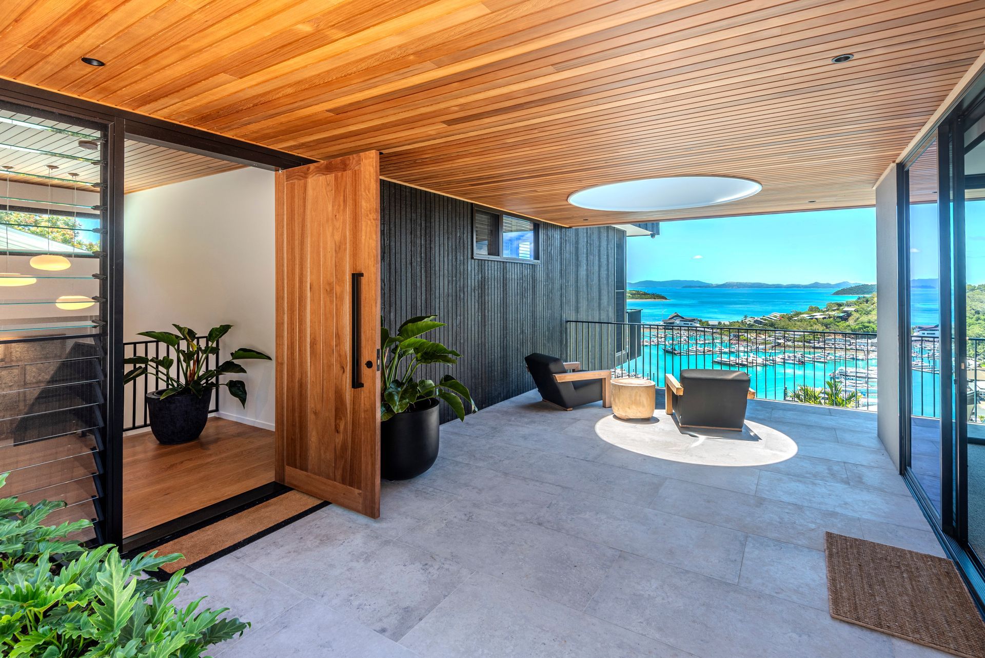 Modern Home Entrance With Wooden Door, Waterfront View, Wooden Ceiling — Red Emperor Constructions in Cannonvale, QLD
