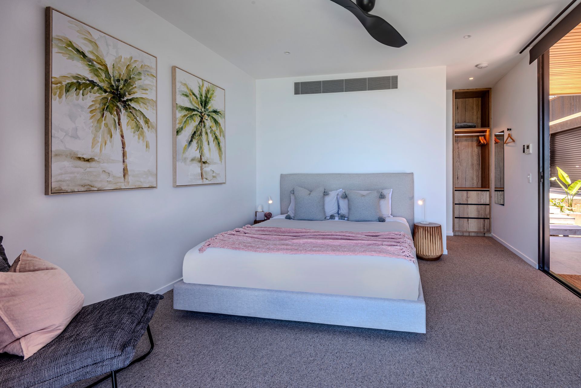 Bedroom With Bed, Palm Tree Artwork, and a Small Side Table — Red Emperor Constructions in Cannonvale, QLD