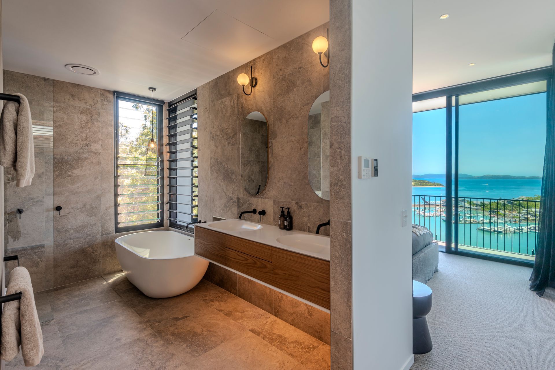 Modern Bathroom With Freestanding Tub, Dual Sinks, and Ocean View — Red Emperor Constructions in Cannonvale, QLD