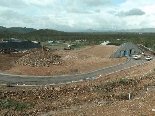 A large pile of dirt is sitting on top of a hill next to a road — Red Emperor Constructions in Cannonvale, QLD
