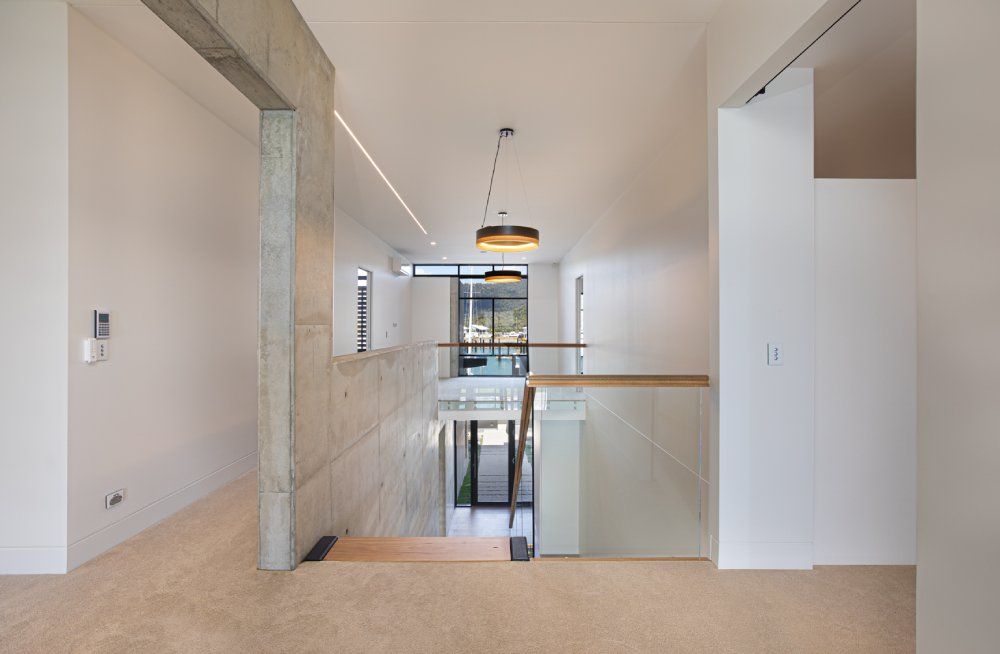A hallway in a house with a staircase leading up to the second floor — Red Emperor Constructions in Cannonvale, QLD