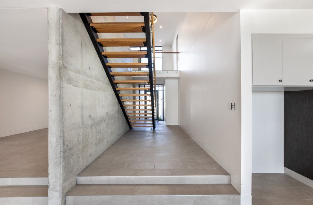 There is a staircase in the middle of the hallway — Red Emperor Constructions in Cannonvale, QLD