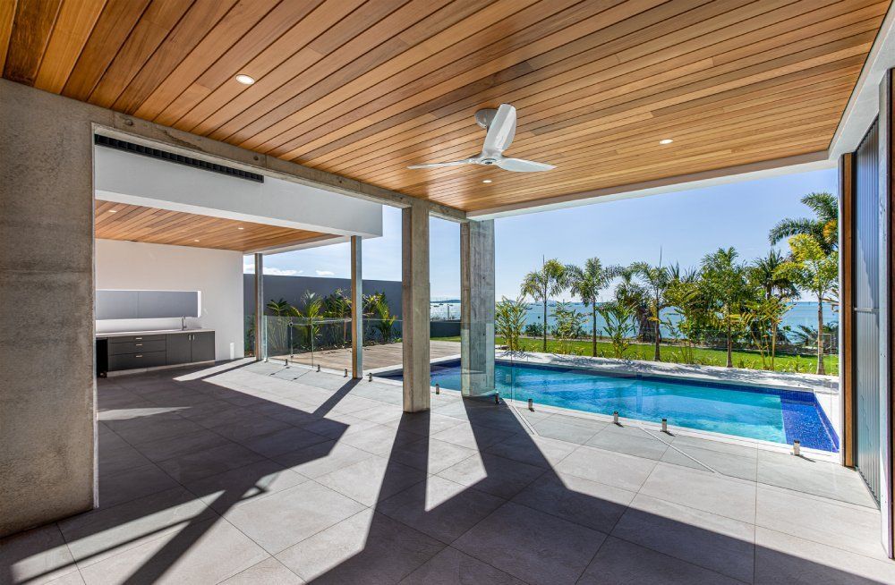 There is a large swimming pool in the middle of the house — Red Emperor Constructions in Cannonvale, QLD