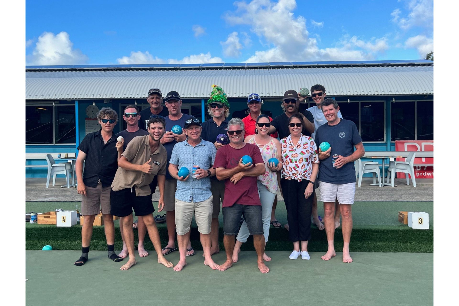 A group of people are posing for a picture while holding bowling balls — Red Emperor Constructions in Cannonvale, QLD