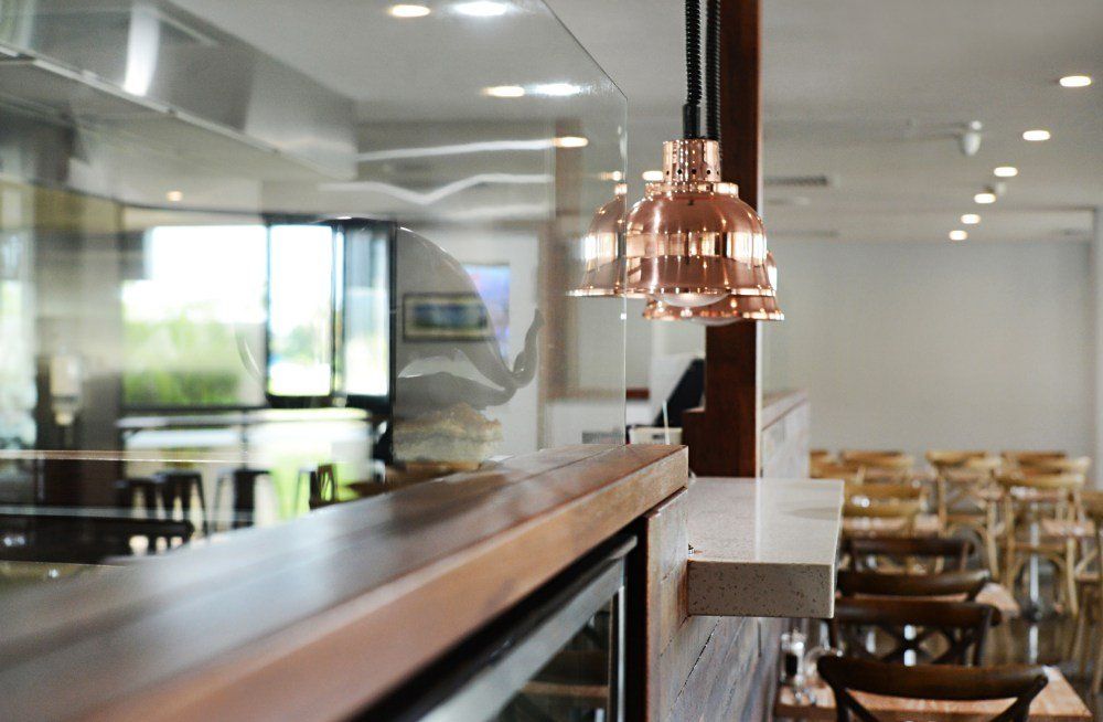 A restaurant with copper pendant lights hanging from the ceiling — Red Emperor Constructions in Cannonvale, QLD