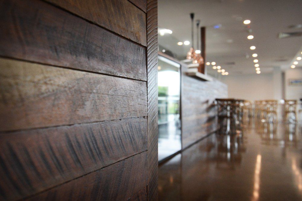 A wooden wall in a restaurant with a bar in the background — Red Emperor Constructions in Cannonvale, QLD