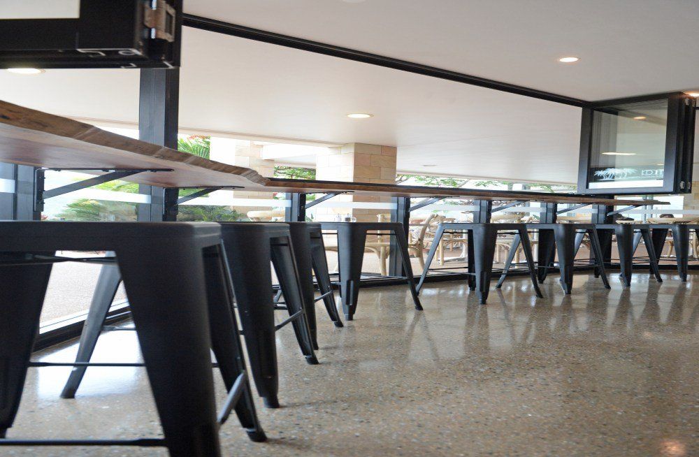 A row of black stools are lined up in a restaurant — Red Emperor Constructions in Cannonvale, QLD