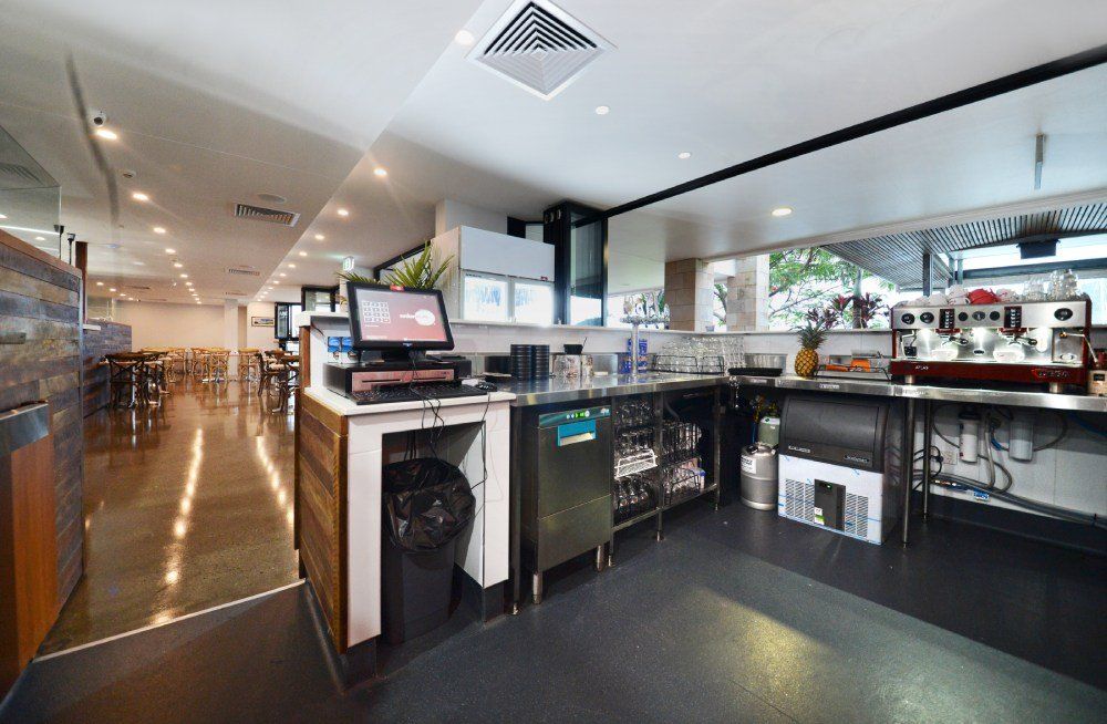 A restaurant with a lot of counters and tables and a coffee machine — Red Emperor Constructions in Cannonvale, QLD