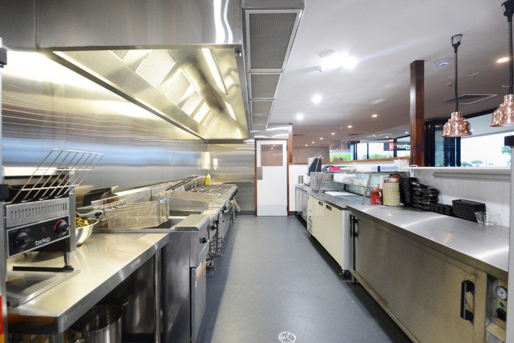 A long kitchen with a lot of stainless steel appliances — Red Emperor Constructions in Cannonvale, QLD