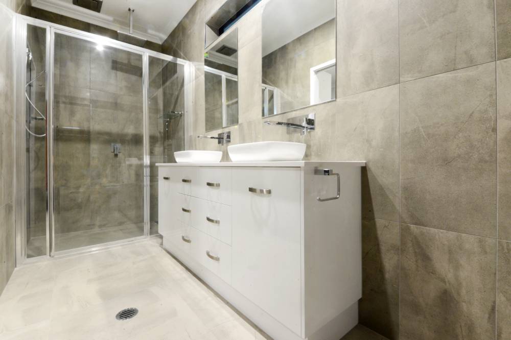 A bathroom with two sinks and a walk in shower — Red Emperor Constructions in Cannonvale, QLD