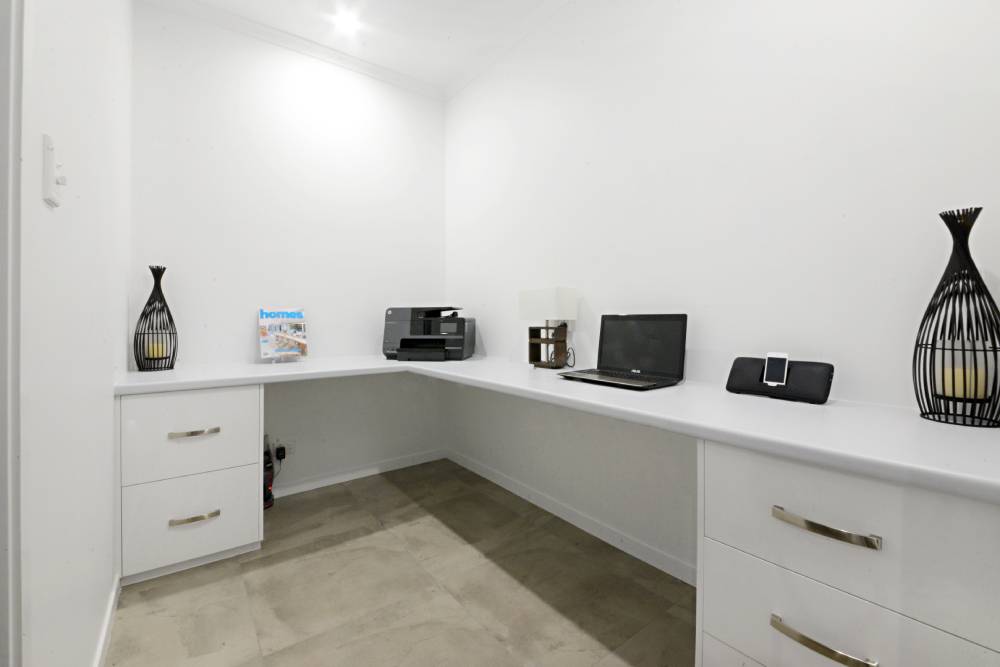 A home office with a desk , laptop , printer and vases — Red Emperor Constructions in Cannonvale, QLD