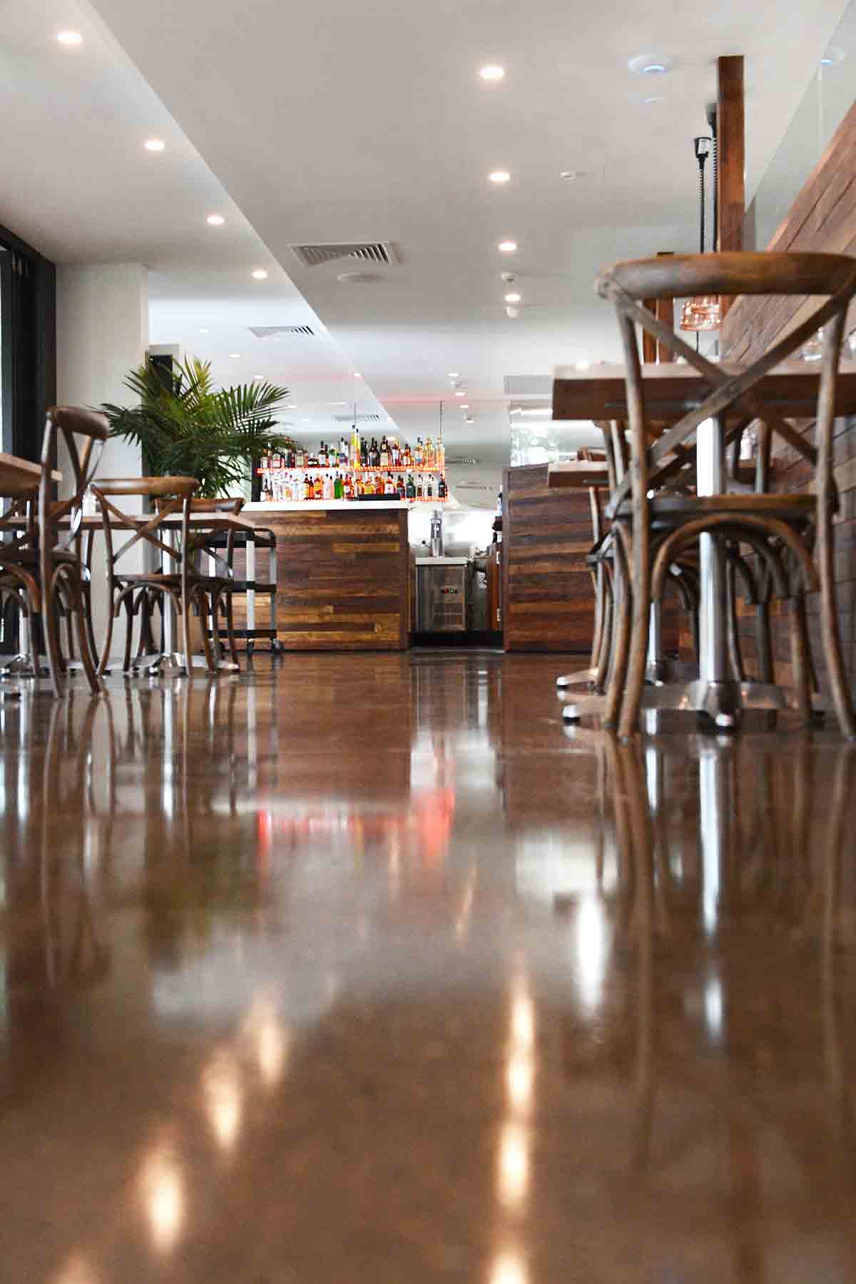 A restaurant with tables and chairs and a shiny floor — Red Emperor Constructions in Cannonvale, QLD